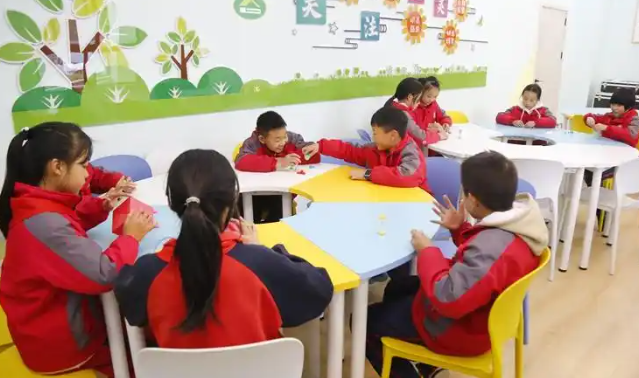 同学们正一起拼搭心情积木五颜六色的积木块在他们手中逐渐成